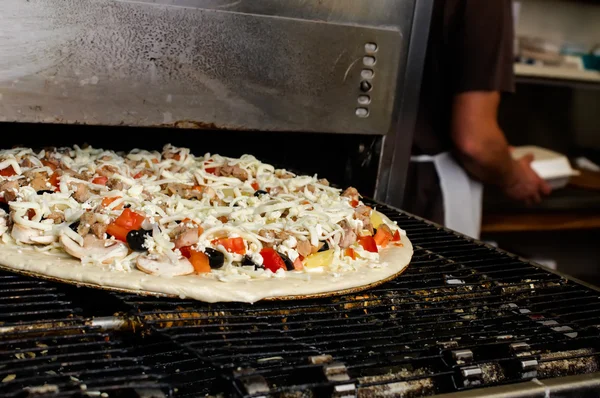Cuocere la pizza nel forno commerciale . — Foto Stock