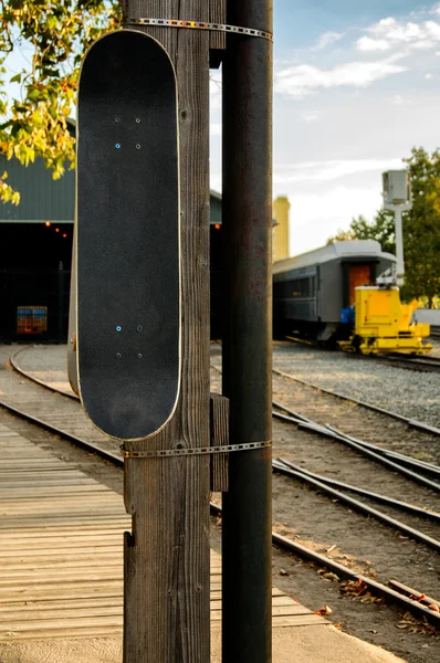Skateboard on a wooden light pole — Stock Photo, Image