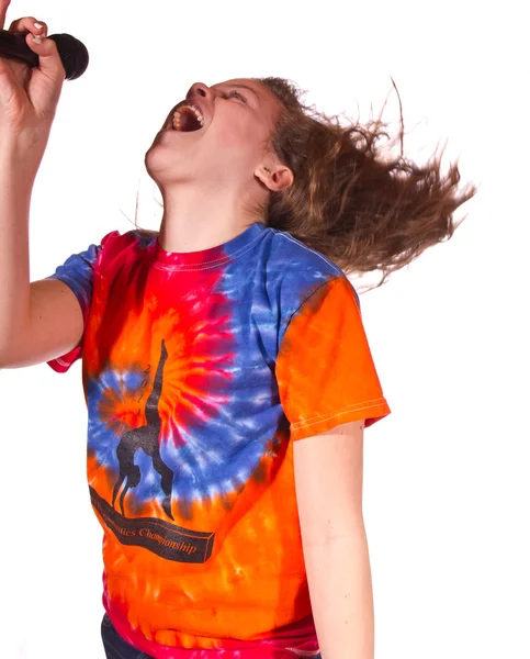 Teen flicka sjunga i en mikrofon Stockbild