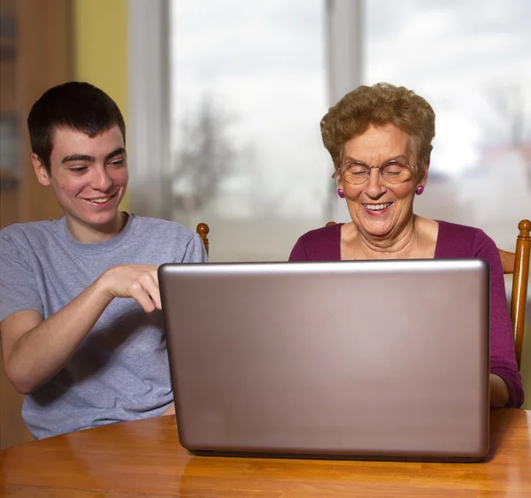 Sonson och mormor på en bärbar dator Royaltyfria Stockbilder