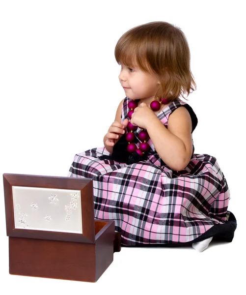 The little girl opens a box with a beads — Stock Photo, Image
