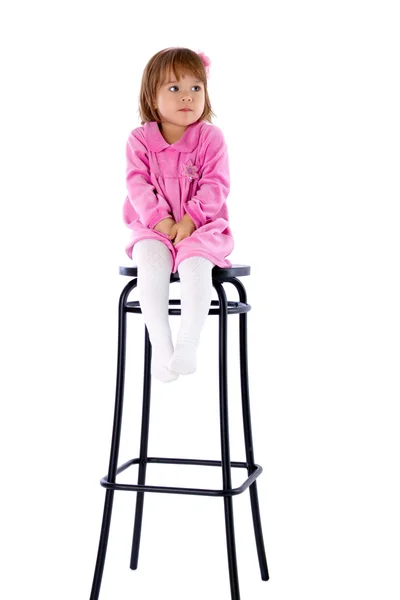 Den lilla flickan sitter på en hög stol — Stockfoto