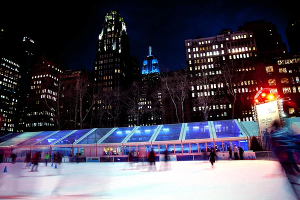 アイス スケート リンクのブライアント公園のニューヨーク市のスカイラインの夜 — ストック写真