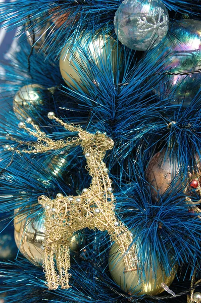 Adorno de ciervo dorado en árbol de navidad azul —  Fotos de Stock