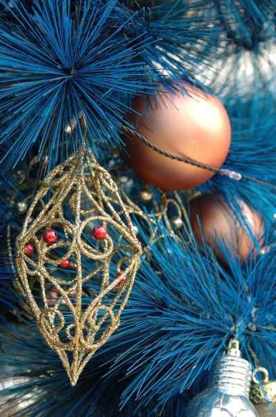 Gouden sieraad op blauwe kerstboom — Stockfoto