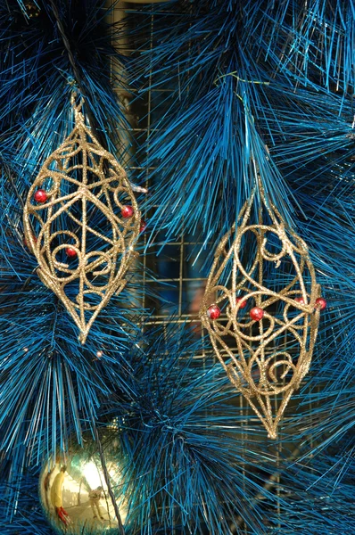 Ornamentos dourados na árvore de Natal azul — Fotografia de Stock