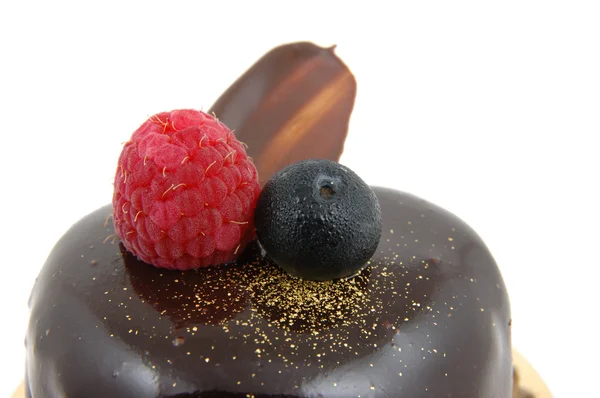 Primer plano de pastel de chocolate con cobertura de frambuesa y arándanos — Foto de Stock