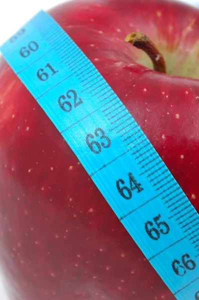 Красное яблоко с измерительной лентой — стоковое фото