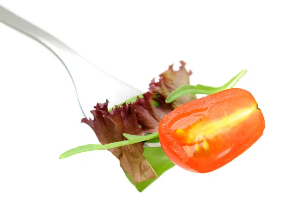 Салат и помидор на вилке — стоковое фото