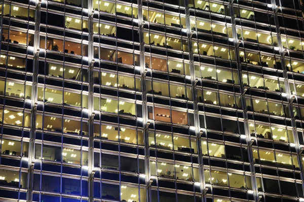 Окна офисного здания ночью — стоковое фото