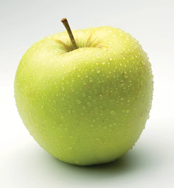Green apple in drops on a white — Stock Photo, Image