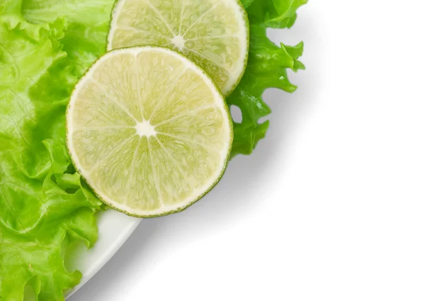 Limetten und Salat auf dem Teller — Stockfoto