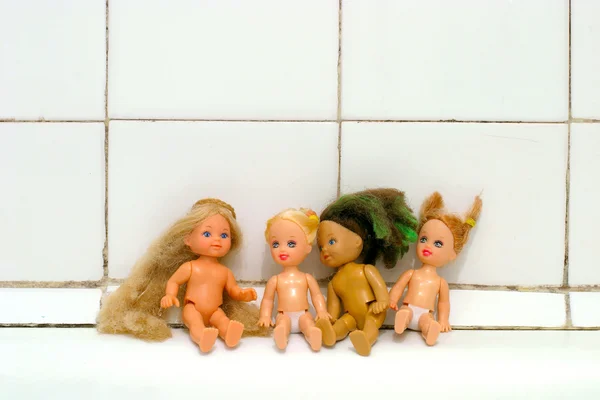 Muñecas en el borde del baño —  Fotos de Stock