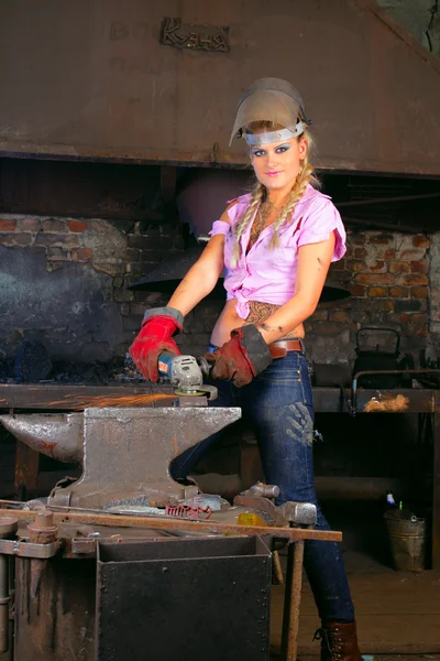 Atrakcyjny dziewczynka w warsztacie z narzędziem w ręku — Zdjęcie stockowe