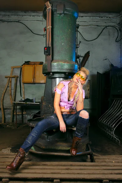 stock image Girl with cigarette sitting in the worksop