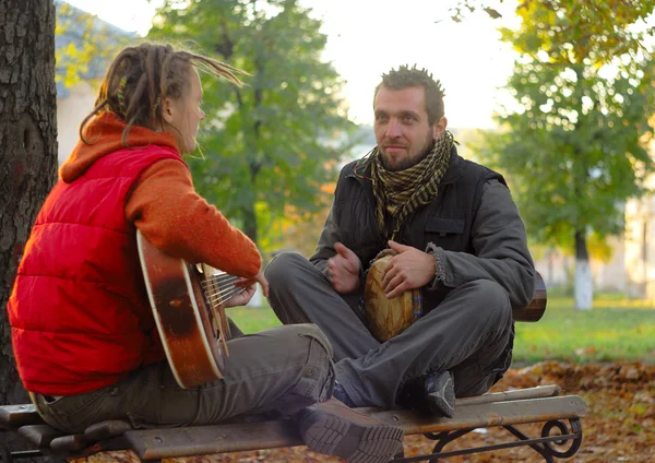 Para młodych muzyków siedzi w ziemi — Zdjęcie stockowe
