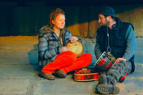 Par av unga musiker sitter i marken — Stockfoto