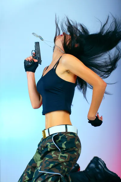 Girl with gun in jump action — Stock Photo, Image