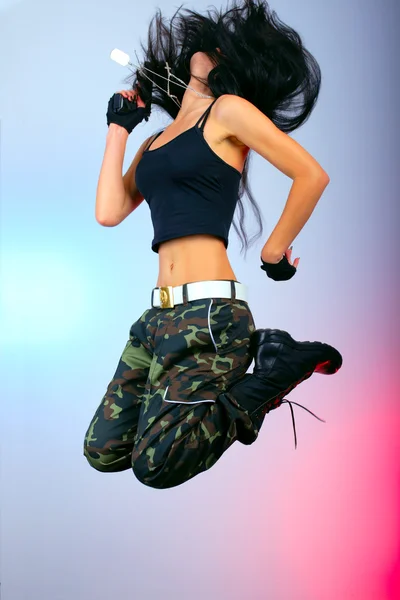 Girl with gun in jump action — Stock Photo, Image