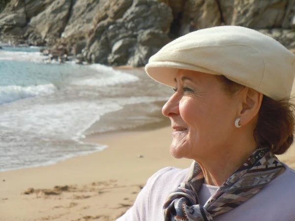Улыбающаяся пожилая женщина смотрит на море — стоковое фото