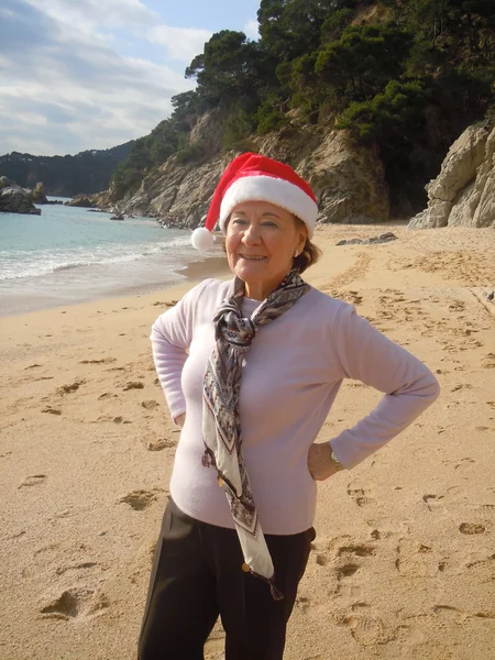 サンタの帽子を持つ年配の女性の笑みを浮かべてください。 — ストック写真
