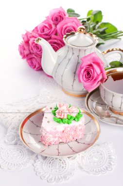 Сake with roses and cup of tea clipart