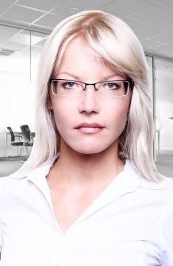 Young attractive business women smiling wearing glasses holding a folder in an office environment clipart