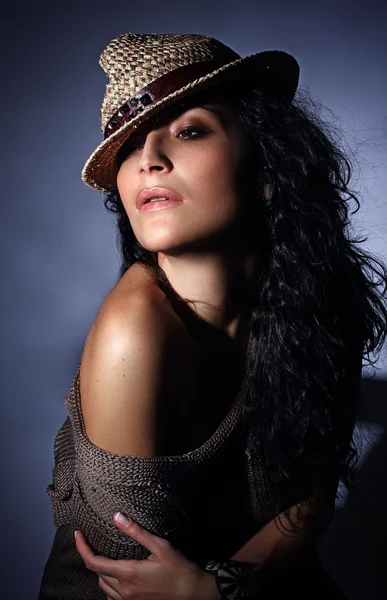 Retrato joven modelo de moda italiana con piel perfecta sobre fondo azul oscuro con sombrero elegante — Foto de Stock