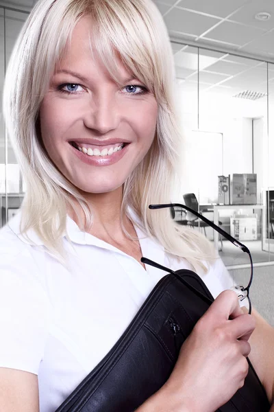 Młody atrakcyjny biznes kobiety uśmiechający się noszenie okularów gospodarstwa folder w środowisku biurowym — Zdjęcie stockowe