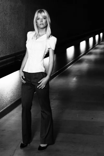 Молода блондинка модель дівчина крупним планом портрет на початку 30-х або 20-х дивиться прямо в білій сорочці з білими перлами з вогнями на фоні тунелю — стокове фото