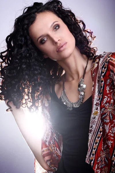 Retrato de um jovem modelo de glamour da moda brasileira e olhos verdes vestindo peles brincando com cabelos castanhos escuros encaracolados — Fotografia de Stock