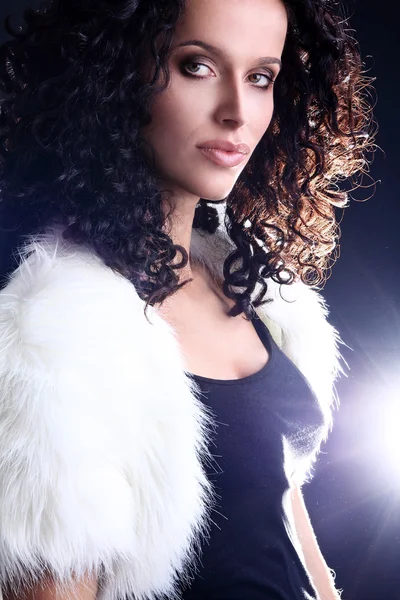 Portrait of a young Brazilian fashion glamour model and green eyes wearing fur playing with dark brown curly hair — Stock Photo, Image