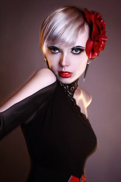 Incomum jovem modelo loira moda posando vestindo um estranho vestido vermelho preto estúdio tiro misturado relâmpago longa velocidade do obturador — Fotografia de Stock