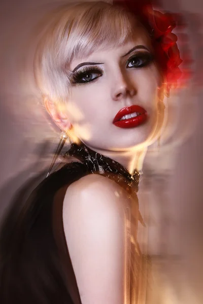 Незвичайна молода модель блондинки позує в дивній чорно-червоній сукні студії дробу змішаної блискавки довга швидкість затвору — стокове фото