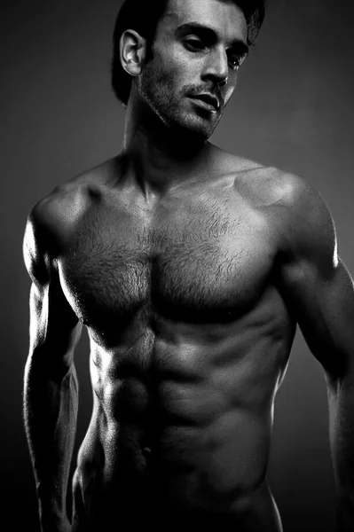 Sexy retrato de arte fina de um modelo masculino sem camisa muito muscular olhando Fotos De Bancos De Imagens