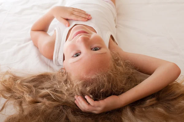 Portrait of a child on the bed with her hair — Stock Photo, Image