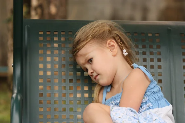 Triest klein kind op een bankje — Stockfoto