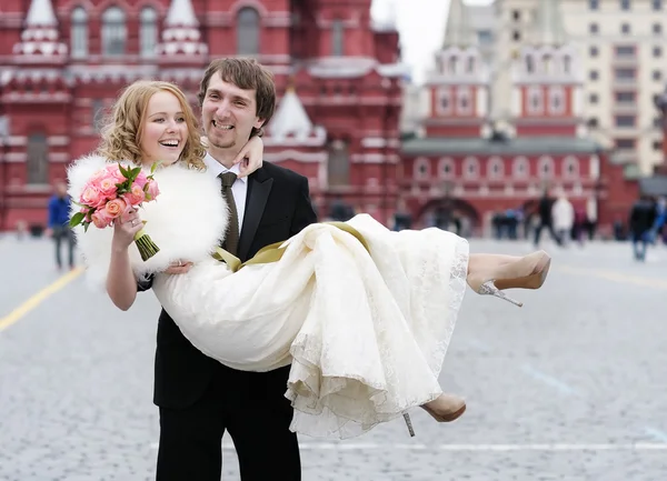 Sposo tenendo giovane bella sposa tra le braccia — Foto Stock