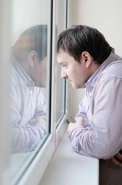 Homme regardant par la fenêtre — Photo