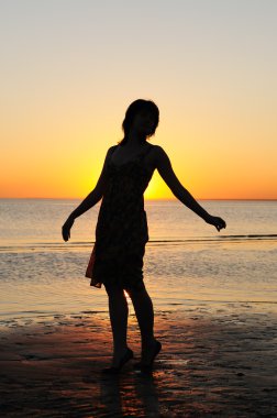 vrouw als silhouet door de zee