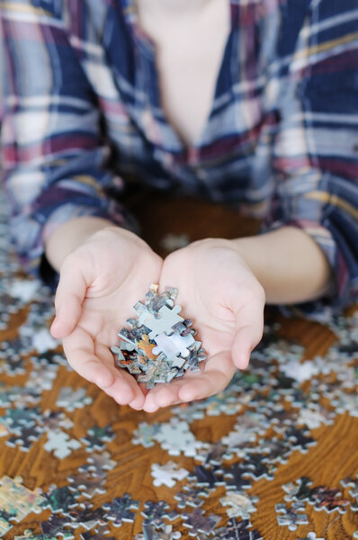 Pieces of puzzle in hands