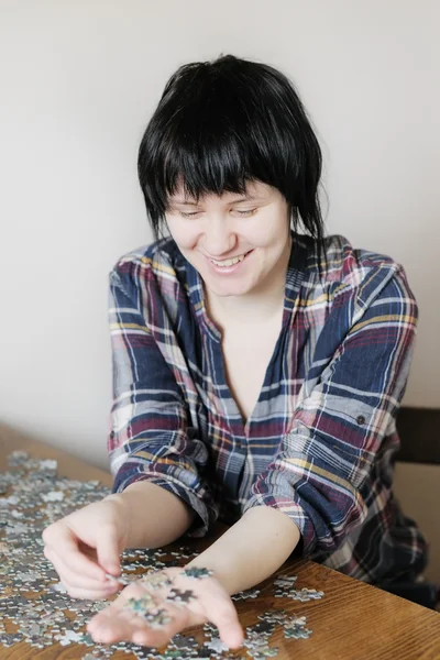 Молодая женщина с кусками головоломки — стоковое фото