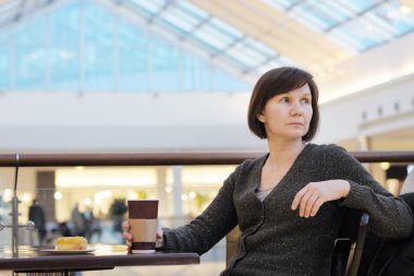 Thoughtful middle age woman with coffee clipart