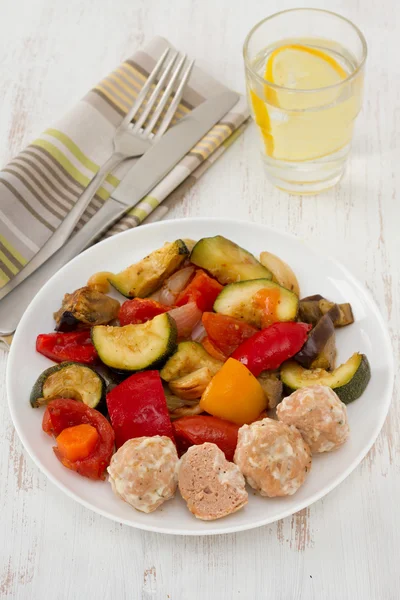 Фрикадельки из индейки с соусом и овощами на тарелке — стоковое фото