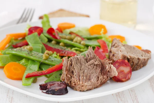 Boiled meat with sausages and vegetable salad — Stock Photo, Image
