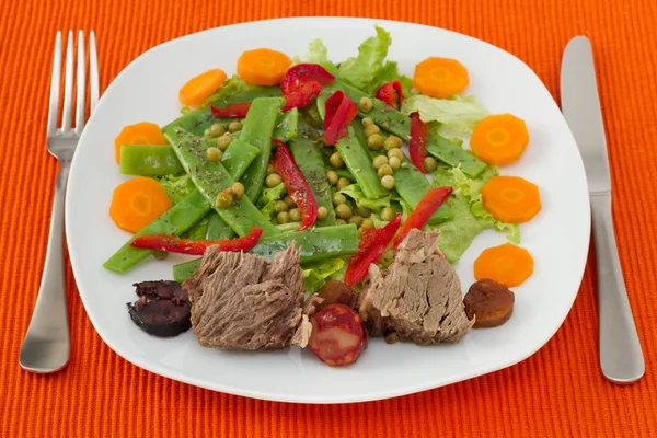 Вареное мясо с сосисками и овощным салатом — стоковое фото