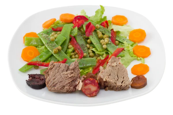Варене м'ясо з ковбасками та овочевим салатом — стокове фото