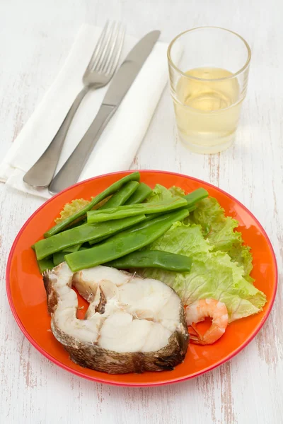 Gekochter Fisch mit Bohnen und Salat auf dem Teller — Stockfoto