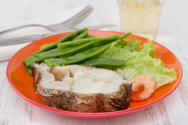 Kokt fisk med bönor och sallad på tallriken — Stockfoto