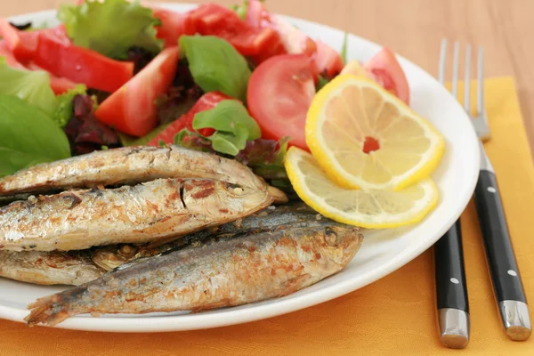 Fried sardines with lemon and salad — Stock Photo, Image